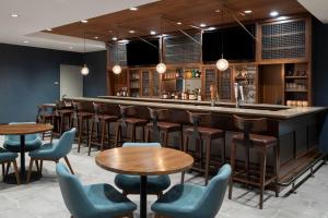 a bar in a restaurant with wooden tables and chairs at Four Points by Sheraton Rock Springs in Rock Springs