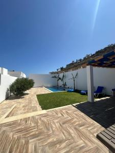 a backyard with a wooden floor and a swimming pool at Diar Jabal Villa S2 in Banī ‘Aţāʼ