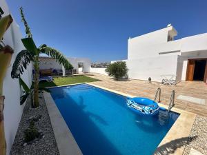 a swimming pool in front of a house at Diar Jabal Villa S2 in Banī ‘Aţāʼ