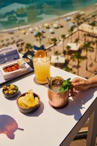 a table with a drink and a view of a beach at Hotel El Puerto by Pierre Vacances in Fuengirola