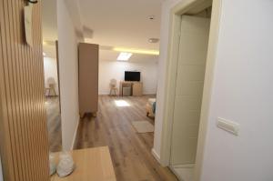 a hallway with a room with a television and a room with a door at Marevento Hotel in Costinesti