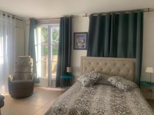 a bedroom with a bed and a chair and a window at Havre de paix in Cluny