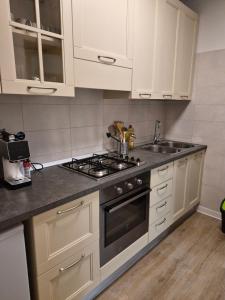 a kitchen with white cabinets and a stove top oven at Nuvola in Ravascletto