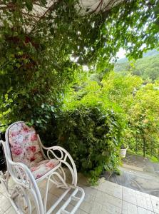 a pair of white chairs sitting on a patio at Tre Bujtinat Gjinar in Elbasan