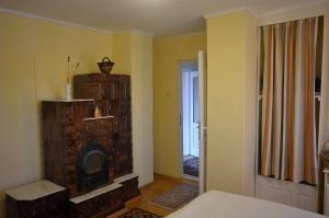 a bedroom with a fireplace in the corner of a room at Casă de oaspeți autentică în Transilvania in Izvoru Mureşului