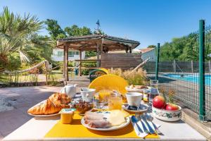 a table with food on it in front of a pool at Hôtel Le Parasol in Ars-en-Ré