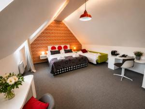 ein Dachzimmer mit zwei Betten und einem Schreibtisch in der Unterkunft LH Vintage Design Hotel Sax in Prag