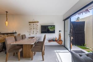 a dining room with a table and chairs at Casa inteligente com 4 suítes e piscina - 160D in Japaratinga