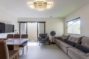 a living room with a couch and a table at Casa inteligente com 4 suítes e piscina - 160D in Japaratinga
