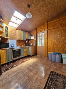 a large kitchen with wooden cabinets and a window at Jaśmin in Budry