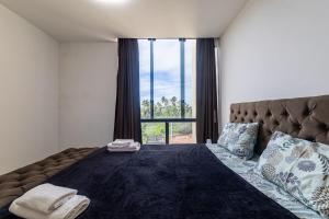 a bedroom with a large bed with a large window at Casa inteligente com 4 suítes e piscina - 160D in Japaratinga +31 photos