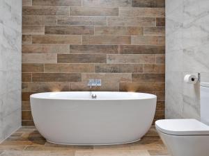 a white bath tub in a bathroom with a toilet at Longcroft Dairy in Oyne