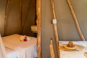 a room with a bed with a hat on a table at Treehouse Kitecamp Jericoacoara in Jericoacoara