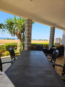 a table on a patio with a view of the beach at Villetta Lu Sule in Porto Cesareo