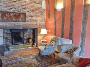 a living room with two chairs and a fireplace at Red Lion Corner in Lavenham