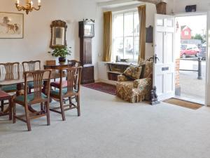 a dining room with a table and chairs and a couch at Red Lion Corner in Lavenham