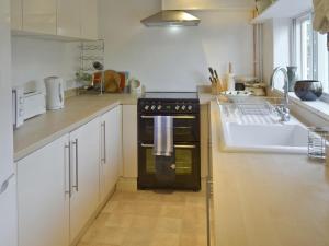 a kitchen with a black oven and a sink at Red Lion Corner in Lavenham +9 photos