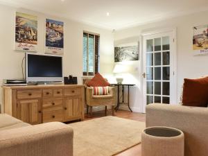 a living room with a tv on a wooden dresser at Sycamore Lodge in Sewerby