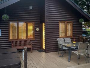 a house with a table and chairs on a deck at Sycamore Lodge in Sewerby