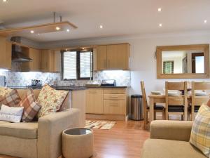 a living room with a couch and a kitchen at Sycamore Lodge in Sewerby +10 photos