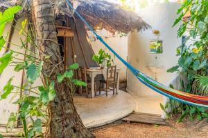 a room with a hammock outside of a house at Treehouse Kitecamp Jericoacoara in Jericoacoara