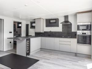a kitchen with white cabinets and black appliances at Mandarin Lodge - Uk51936 in Yarm