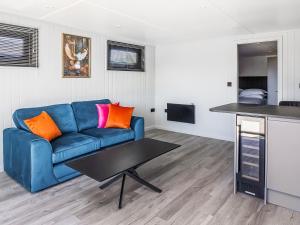 a living room with a blue couch and a table at Mandarin Lodge - Uk51936 in Yarm