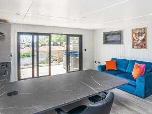 a living room with a table and a blue couch at Mandarin Lodge - Uk51936 in Yarm