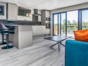 an open kitchen with a blue couch and a table at Mandarin Lodge - Uk51936 in Yarm +2 photos