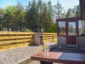 a wooden table with two wine glasses on it at Lowesmuir Cottage in Cumnock