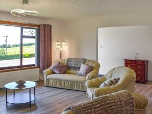 a living room with two couches and a table at Lowesmuir Cottage in Cumnock +11 photos