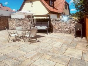 a patio with a table and chairs and a stone wall at Royal Border Retreat in Berwick-Upon-Tweed