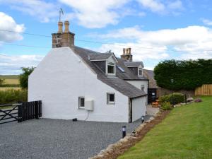 a white house with a black roof at Longcroft Cottage - 28233 in Oyne