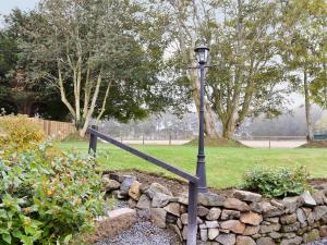 a street light next to a stone wall at Longcroft Cottage - 28233 in Oyne