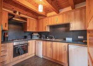a large kitchen with wooden cabinets and appliances at Benview Holiday Lodges in Gartmore