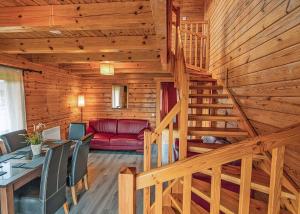 a staircase in a log cabin with a red couch at Benview Holiday Lodges in Gartmore