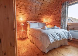 a bedroom with a large bed in a wooden room at Benview Holiday Lodges in Gartmore +13 photos