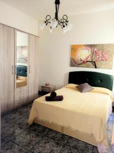 a bedroom with a large bed and a chandelier at Silia's Maisonette in Marsaskala