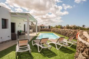 a villa with a swimming pool and patio furniture at Villa La Era 2 in El Cotillo