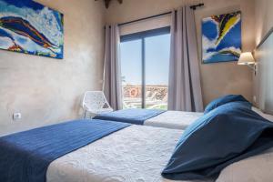 a bedroom with two beds and a window with a view at Villa La Era 2 in El Cotillo +19 photos