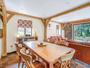 a living room with a wooden table and chairs at Y Beudy - Uk49917 in Penclawdd