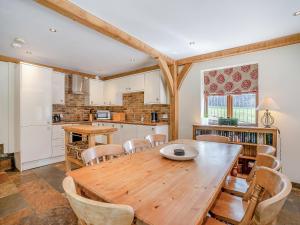 a kitchen and dining room with a wooden table and chairs at Y Beudy - Uk49917 in Penclawdd