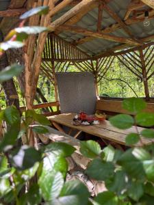 a picnic table in a bamboo hut with trees in the background at Rob Guest House in Garni +13 photos