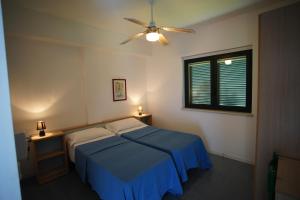 a bedroom with a bed and a ceiling fan at Residenze Sant'Andrea in Isca Marina