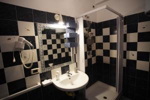 a black and white bathroom with a sink and a shower at Residenze Sant'Andrea in Isca Marina