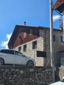 a car parked in front of a stone building at La Tana - Borno Holiday in Borno