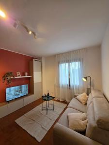 a living room with a couch and a table at La Tana - Borno Holiday in Borno