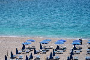 a group of chairs and umbrellas on a beach at Hotel Orizzonte in Letojanni