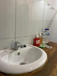 a white sink in a bathroom with a mirror at Bayan Exotic Homestay in Senaru