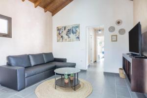 a living room with a couch and a tv at Villa La Era 1 in El Cotillo